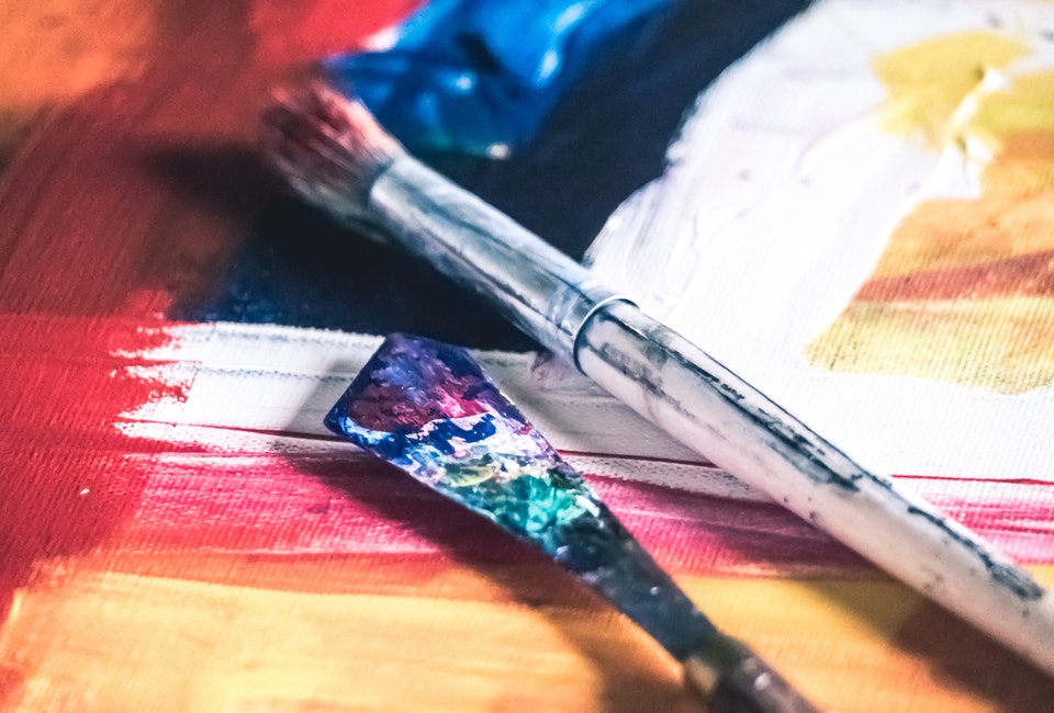 Two paintbrushes on a colorful canvas
