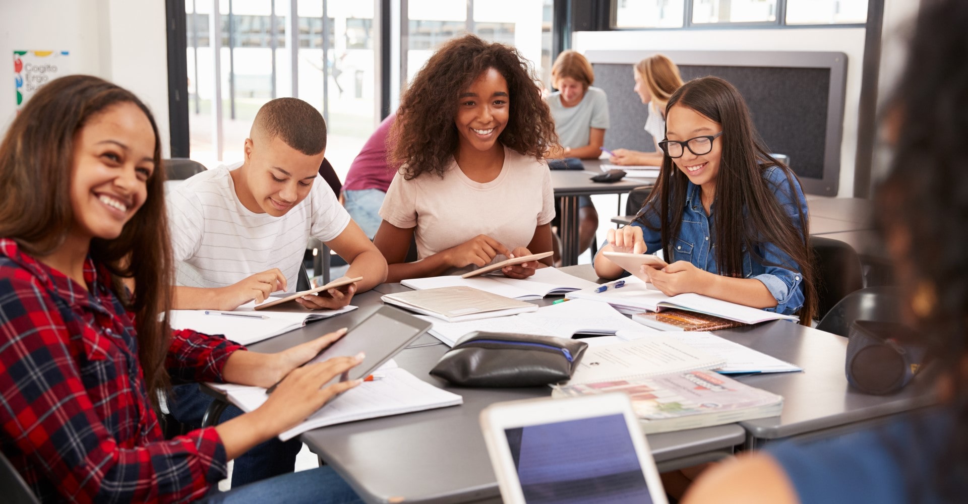 Four youths smile in a classroom