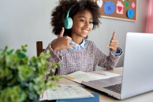 A young child does sign language during a laptop video call