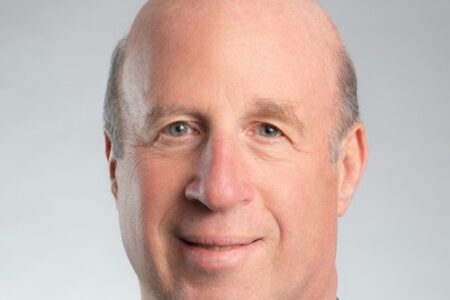 A close-up headshot of a Scott Hefter. The photo is taken against a plain, light grey background.