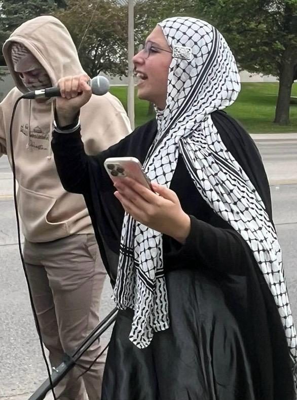 Young woman wearing a hijab, protesting